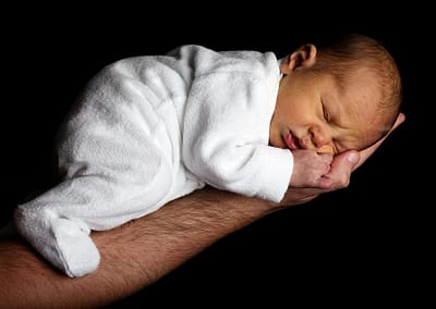 Baby-auf-hand-schwarzer-hintergrund